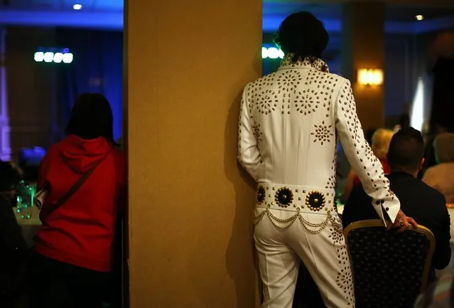 An amateur entrant watches a competitor sing during the annual European Elvis Tribute Artist Contest and Convention in Birmingham, central England January 2, 2015. (Photo by Darren Staples/Reuters)