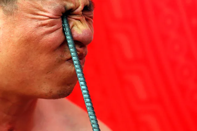 Ngo Chien Thuat, a traditional health worker, bends a metal pole by pressing it into his eye as he performs during a showcase of the traditional Thien Mon Dao kung fu at Du Xa Thuong village in Vietnam, May 7, 2018. (Photo by Reuters/Kham)