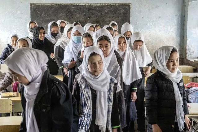 Girls stand in their classroom on the first day of the new school year, in Kabul, Saturday, March 25, 2023. The new Afghan educational year started, but high school remained closed for girls for the second year after Taliban returned to power in 2021. (Photo by Ebrahim Noroozi/AP Photo)