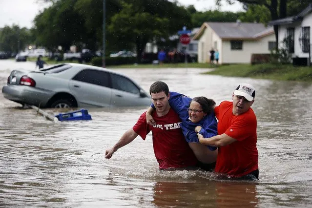 Marco Fairchild and Gary Garza help Sueann Schaller from her car in San Antonio after she drove it into floodwaters in the Westwood Village neighborhood, on May 25, 2013.  (Photo by Lisa Krantz/San Antonio Express-News)