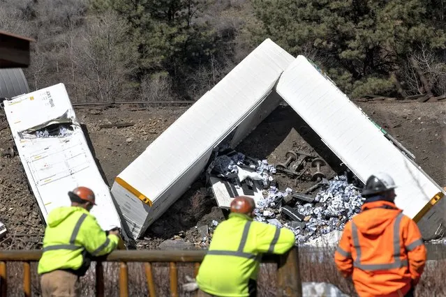 Montana Rail Link employees look across the river at rail cars which were derailed near Quinn's Hot Springs, west St. Regis, Mont., Sunday, April 2, 2023. (Photo by Ben Allan Smith/The Missoulian via AP Photo)