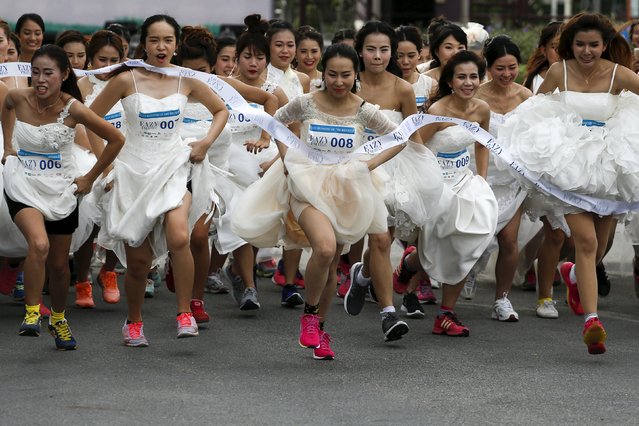 Brides-to-be participate in the "Running of the Brides" race in a park in Bangkok November 28, 2015. A hundred husbands and wives-to-be wore their wedding dresses and running shoes and competed in an event for a combined prize worth 1 million Thai baht ($27,928), according to the organisers. (Photo by Athit Perawongmetha/Reuters)