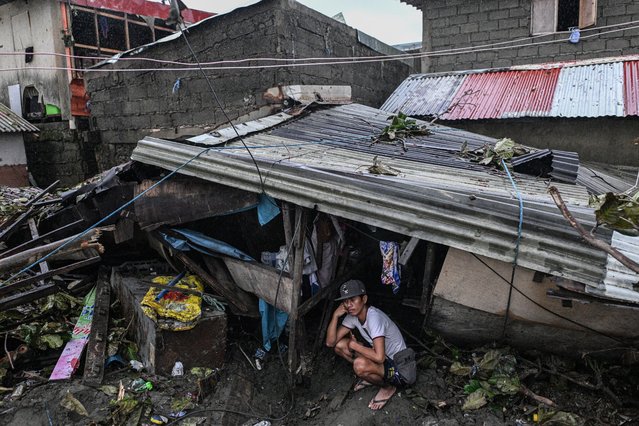 A man sits under the roof of his house damaged by storm surges after Typhoon Fung-wong hit the coast of Bonuan City, Pangasinan, Philippines, on November 10, 2025. (Photo by Noel Celis/Reuters)