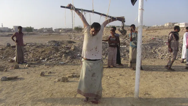 The body of a man is seen tied to a soccer goal post after al Qaeda militants shot him to death, accusing him of spying for the United States outside al-Shihr city of the southeastern Yemeni province of Hadhramout March 6, 2014. (Photo by Reuters/Stringer)