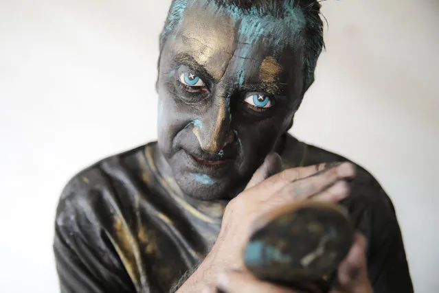 In this Sunday, May 27, 2018, photograph, Portuguese artist Antonio Santos checks his make-up during the Living Statues International Festival, in Bucharest, Romania. Up to thirty thousand people enjoyed a week of street performances by reputed artists from eight countries in the “largest European festival of the genre”. (Photo by Vadim Ghirda/AP Photo)