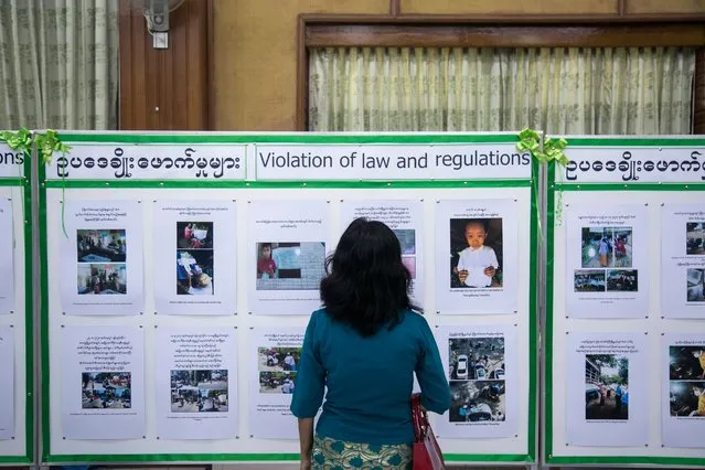 A woman looks at a notice board with information alleging election irregularities during a Union Solidarity and Development Party (USDP) press conference where party officials denounced the recent election as fraudulent in Yangon on November 26, 2020. (Photo by Sai Aung Main/AFP Photo)