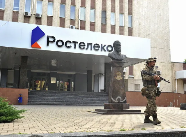 A serviceman from private military company (PMC) Wagner Group blocks the access to the Rostelecom building in Rostov-on-Don, southern Russia, 24 June 2023. (Photo by Arkady Budnitsky/EPA)