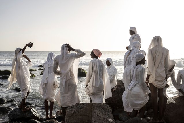 Dressed in white robes to symbolize purity and equality before God, followers from the Layene brotherhood gather near a sacred grotto where they believe their prophet received divine inspiration, in Ngor, Senegal, Thursday, January 30, 2025. (Photo by Annika Hammerschlag/AP Photo)