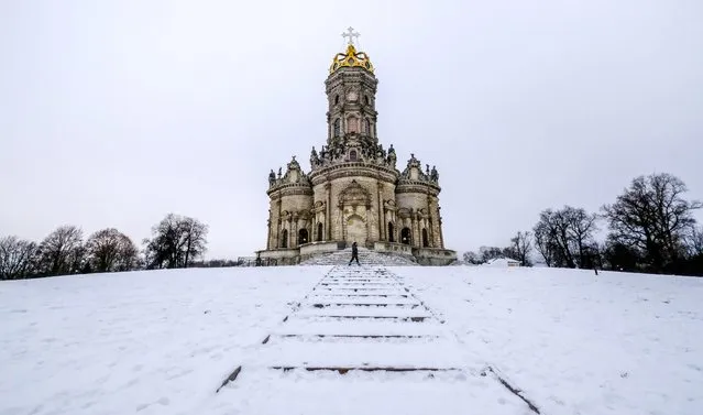 A woman walks past the Church of the Mother of God Holy Sign in the town of Podolsk outside Moscow on December 22, 2020. (Photo by Yuri Kadobnov/AFP Photo)