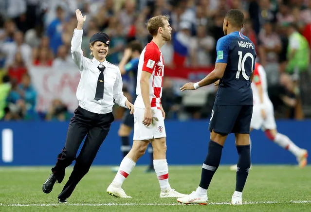 A pitch invader (p*ssy Riot member) runs past Croatia's Ivan Strinic and France's Kylian Mbappe during the Russia 2018 World Cup final football match between France and Croatia at the Luzhniki Stadium in Moscow on July 15, 2018. (Photo by Darren Staples/Reuters)