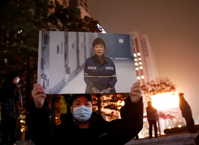 A protester holds a computerized image of South Korean President Park Geun-hye, at a candlelight protest demanding President Park step down over a recent influence-peddling scandal, in central Seoul, South Korea, November 18, 2016. (Photo by Kim Kyung-Hoon/Reuters)