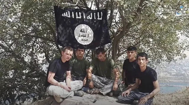 This grab taken from video, made available by Aamaq news agency of the Islamic State group, shows five men sitting on a hill against the backdrop of a black-and-white IS flag and declaring allegiance to IS leader Abu Bakr al-Baghdadi. The Islamic State group on Tuesday July 31, 2018 claimed responsibility for a car-and-knife attack on Western tourists cycling in Tajikistan that killed two Americans and two Europeans. (Photo by Aamaq news agency of the Islamic State group via AP Photo)