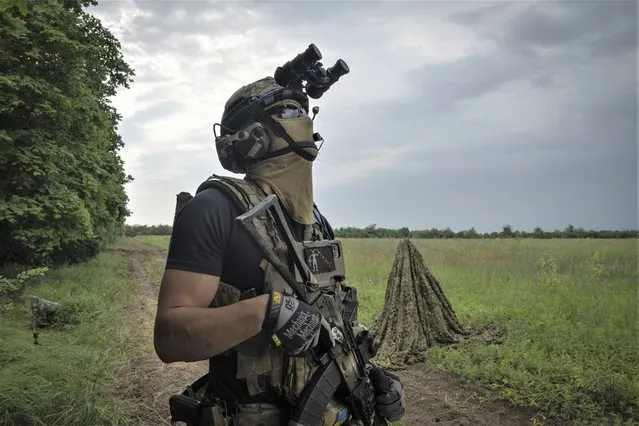 A Ukrainian soldier looks at the sky searching for a drone on the frontline in Zaporizhzhia region, Ukraine, Saturday, June 24, 2023. (Photo by Efrem Lukatsky/AP Photo)