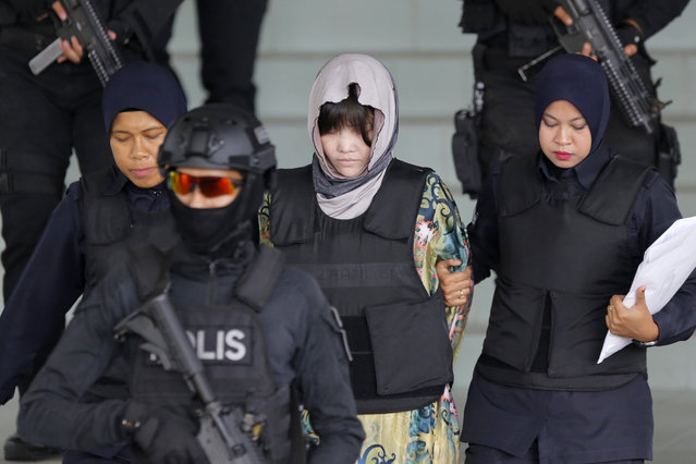 Vietnamese Doan Thi Huong, center, is escorted by police as she leaves her court hearing at the Shah Alam High Court in Shah Alam, Malaysia, Thursday, August 16, 2018. The Malaysian court has ordered the two women, Doan Thi Huong and Indonesian Siti Aisyah to enter their defense over the murder of North Korean leader's half-brother in a brazen assassination that has gripped the world. (Photo by Yam G-Jun/AP Photo)