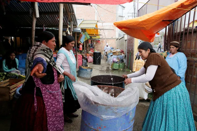 Women recover rain water during a water drought season in Chasquipampa, La Paz, Bolivia, November 28, 2016. (Photo by David Mercado/Reuters)