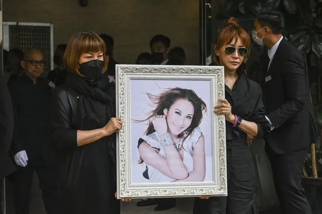 Relatives hold a photo of Coco Lee after her funeral in Hong Kong, Tuesday, August 1, 2023. Lee was being mourned by family and friends at a private ceremony Tuesday a day after fans paid their respects at a public memorial for the Hong Kong-born entertainer who had international success. (Photo by Billy H.C. Kwok/AP Photo)