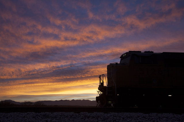 The lead locomotive of a Union Pacific freight train waits on a siding shortly before sunrise, Friday, December 11, 2015, in Sahuarita, Ariz. (Photo by David Boe/AP Photo)