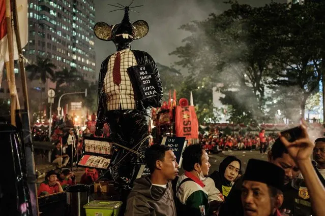 Members of various labor unions protest for better conditions late into the night in front of the Arjuna Wijaya Statue in Jakarta on August 10, 2023. (Photo by Yasuyoshi Chiba/AFP Photo)