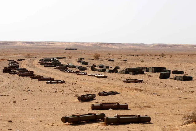 Crates are seen near shells and hand rockets in a desert south of Sirte, Libya October 30, 2011. (Photo by Youssef Boudlal/Reuters)