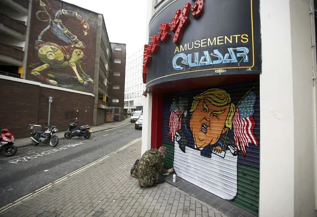 Artist Jack Dones paints a mural of US President elect Donald Trump on the shutter of a former amusement arcade in Bristol, Britain November 18, 2016. (Photo by Peter Nicholls/Reuters)
