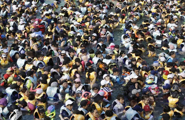 People crowd in the Caribbean Bay swimming pool trying to escape the heat in Yongin, South Korea, Thursday, August 2, 2018. South Korean Meteorological Administration issued a heat wave warning for Seoul and other cities. (Photo by Ahn Young-joon/AP Photo)