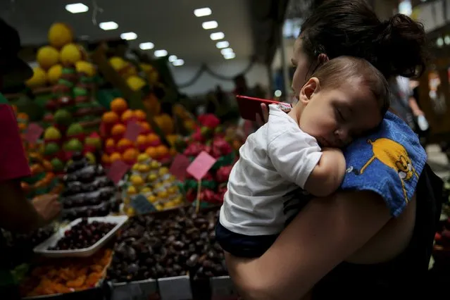 A woman holds her baby before buying fruit at the Municipal Market in Sao Paulo, Brazil, January 7, 2016. (Photo by Nacho Doce/Reuters)