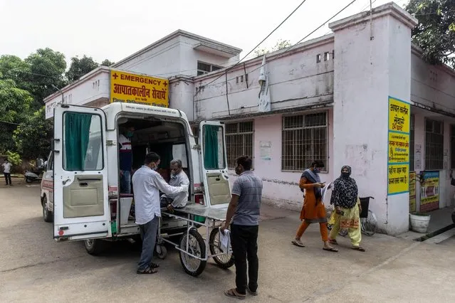 Relatives help Jagdish Singh, 57, out of an ambulance outside a government-run hospital to receive treatment, amidst the coronavirus disease (COVID-19) pandemic, in Bijnor district, Uttar Pradesh, India, May 11, 2021. (Photo by Danish Siddiqui/Reuters)