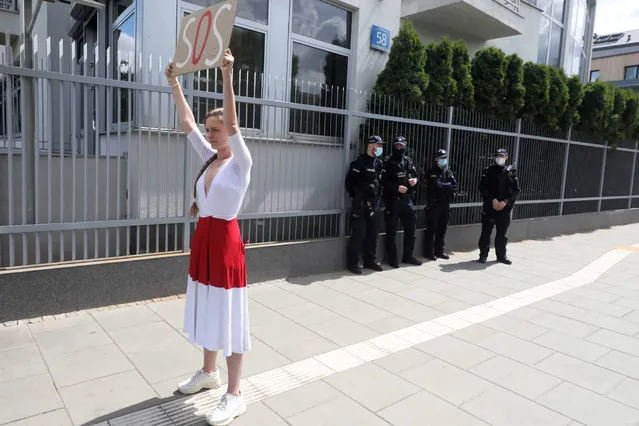 Polish-Belarusian activist Jana Shostak (C) shows a placard “SOS” during a press conference on opposition journalist Roman Protasevich in front of the Embassy of Belarus in Warsaw, Poland, 24 May 2021. Belarus' opposition journalist Roman Protasevich was detained by Belarusian Police on 23 May on a Ryanair flight from Athens to Vilnius, that was forced to land in Minsk. Protasevich arrest was widely condemned by EU leaders, who during a special EU summit on 23 and 24 May will discuss possible economic sanctions on Belarus in response for the accident. (Photo by Tomasz Gzell/EPA/EFE)