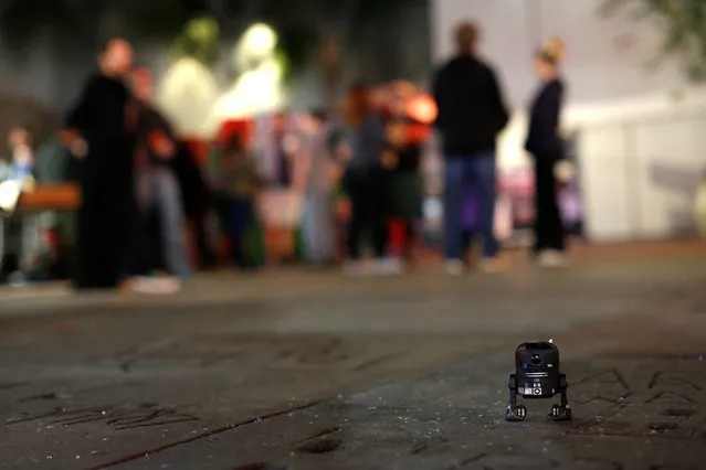 A C2-B5 toy is pictured on the ground while people wait for the first showing of “Rogue One: A Star Wars Story” in the forecourt of the TCL Chinese theatre in Hollywood, California U.S., December 13, 2016. (Photo by Mario Anzuoni/Reuters)