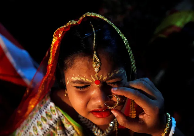 A young girl dressed as a Kumari reacts as a woman puts a nose ring on her, before she is worshipped by Hindu devotees as a part of a ritual during the Durga Puja festival celebrations in Kolkata, India, October 17, 2018. (Photo by Rupak De Chowdhuri/Reuters)