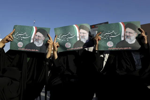Supporters of presidential candidate Ebrahim Raisi hold up his signs during a rally in Tehran, Iran, Monday, June 14, 2021. Iran's clerical vetting committee has allowed just seven candidates for the Friday, June 18, ballot, nixing prominent reformists and key allies of President Hassan Rouhani. The presumed front-runner has become Ebrahim Raisi, the country's hard-line judiciary chief who is closely aligned with Supreme Leader Ayatollah Ali Khamenei. (Photo by Ebrahim Noroozi/AP Photo)