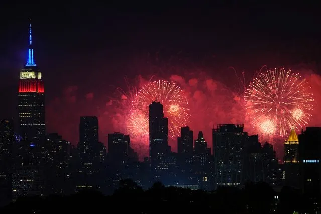 Fireworks explode over the New York City skyline during Macy's 4th of July fireworks display, late Sunday, July 4, 2021, as seen from Jersey City, N.J. (Photo by Charles Sykes/AP Photo)