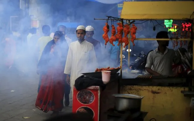 People walk past a roadside food stall outside the shrine of Muslim Sufi Saint Nizamuddin Auliya, in New Delhi April 12, 2015. (Photo by Adnan Abidi/Reuters)