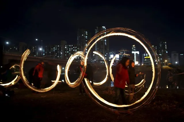 Children whirl cans filled with burning wood chips during a celebration ahead of “Jeongwol Daeboreum” (Great Full Moon), which is a traditional Korean holiday that celebrates the first full moon of the lunar calendar, at a park in Seoul, South Korea, February 21, 2016. (Photo by Kim Hong-Ji/Reuters)