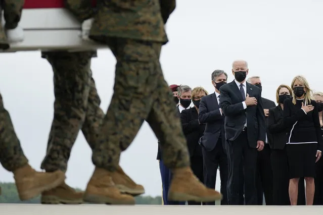 President Joe Biden and first lady Jill Biden watch as a carry team moves a transfer case containing the remains of Marine Corps Lance Cpl. Kareem M. Nikoui, 20, of Norco, Calif., during a casualty return Sunday, August 29, 2021, at Dover Air Force Base, Del. According to the Department of Defense, Nikoui died in an attack at Afghanistan's Kabul airport, along with 12 other U.S. service members. (Photo by Carolyn Kaster/AP Photo)