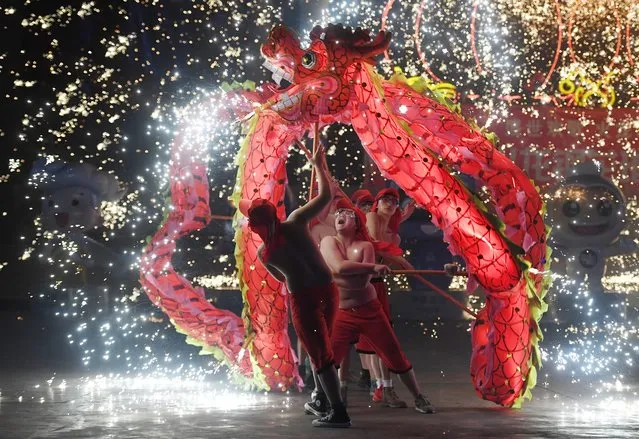 Dragon dancers perform at a park in Beijing on the fourth day of the Lunar New Year on February 8, 2019. China is marking the arrival of the Year of the Pig with a week-long Spring Festival holiday, the most important festival of the year. (Photo by Greg Baker/AFP Photo)