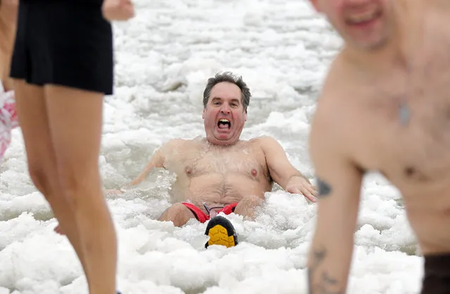 Bud Fox, of Brookfield, is overcome with cold as he lays in the chilly water. The annual Polar Bear Plunge in Milwaukee was held at Bradford Beach on Wednesday, January 1, 2014. (Photo by Mike De Sisti)