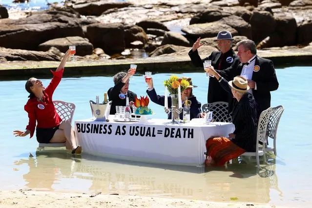 Climate activists from Extinction Rebellion stage a piece of street theatre on a beach during COP27 Water Day, to highlight the fact that fossil fuel “Business as Usual” is leading to climate disasters, such as sea level rise, in Cape Town, South Africa on November 14, 2022. (Photo by Esa Alexander/Reuters)