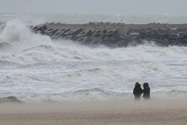 People watch waves break during Storm Ciaran, in Ostend, Belgium on November 2, 2023. (Photo by Yves Herman/Reuters)