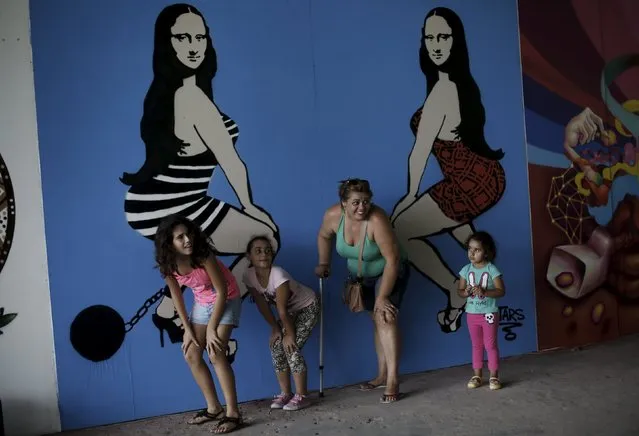 A family pose next to a work by Brazilian artist Tars during the 3th International Biennial Fine Art Graffiti exhibition at the Ibirapuera park in Sao Paulo April 21, 2015. (Photo by Nacho Doce/Reuters)
