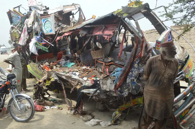 People gather around the wreckage of a bus after an accident in Dera Ghazi Khan, Pakistan, 19 July 2021. At least 33 people died and another 35 were injured on 19 July, in a bus accident near Dera Ghazi Khan. The bus collided with a truck on the Indus highway near the city of Dera Ghazi Khan in the early hours of 19 July. (Photo by Faisal Kareem/EPA/EFE)
