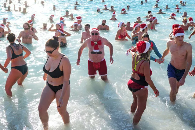 Bathers take part in the traditional Christmas bath in Nice, on the French Riviera, on December 17, 2023. (Photo by Valery Hache/AFP Photo)