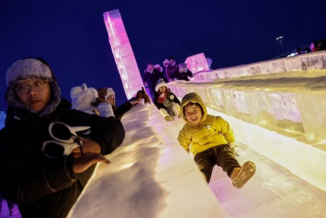 A child rides down an ice slide at the Harbin International Ice and Snow Festival, in Harbin, Heilongjiang province, China on January 4, 2024. (Photo by Tingshu Wang/Reuters)