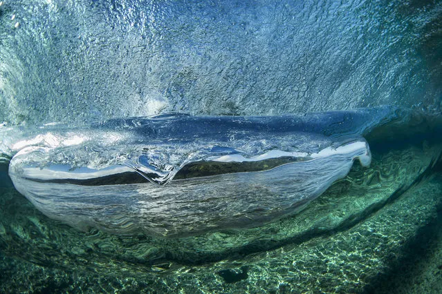 A shot of a wave crashing down into the ocean in the clear waters of Teahupoo. (Photo by Ben Thouard/Caters News)