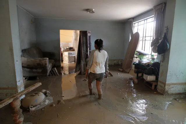 A woman walks inside her house filled with mud after a landslide and a flood occurred in San Juan de Lurigancho distritct, in Lima, Peru February 1, 2017. (Photo by Guadalupe Pardo/Reuters)