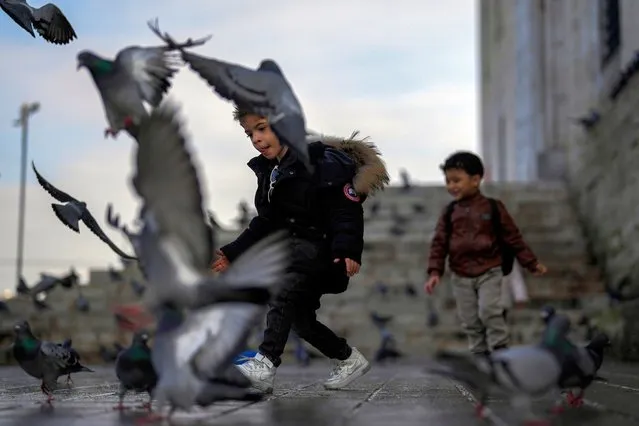 Children play with pigeons next to Yeni Cami (New Mosque) in Istanbul, Turkey, Wednesday, January 17, 2024. (Photo by Francisco Seco/AP Photo)