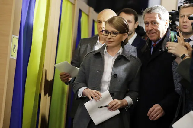 Former Ukrainian Prime Minister Yulia Tymoshenko, a candidate for the   presidential election, center, holds her ballot for casting at a polling station during the presidential election in Kiev, Ukraine, Sunday, March 31, 2019. Ukrainians choose from among 39 candidates for a president they hope can guide the country of more than 42 million out of troubles including endemic corruption, a seemingly intractable conflict with Russia-backed separatists in the country's east and a struggling economy. (Photo by Sergei Grits/AP Photo)