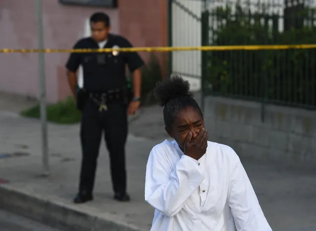 A woman reacts outside The Marathon clothing store owned by Grammy-nominated rapper Nipsey Hussle where he was fatally shot along with 2 other wounded, in Los Angeles on March 31, 2019. In addition to the man who was killed, the two other victims were listed as stable at a hospital, said police, who said a male suspect fled in a car. (Photo by Mark Ralston/AFP Photo)