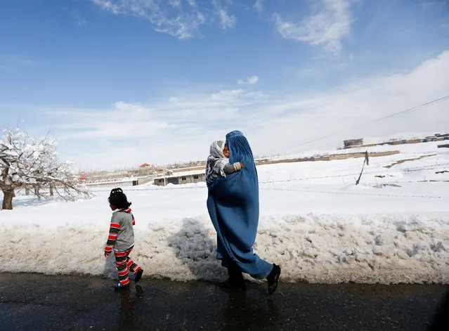 An Afghan woman walks with her children along a street covered with snow on the outskirts of Kabul, Afghanistan February 6, 2017. (Photo by Mohammad Ismail/Reuters)