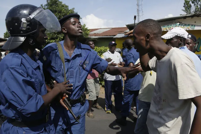 A demonstrator argues with police protesters march through the Musaga district of Bujumbura, in Burundi, Monday, May 11, 2015. (Photo by Jerome Delay/AP Photo)